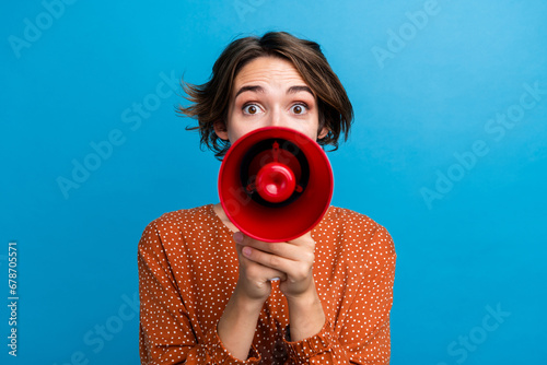 Photo portrait of lovely young lady hold megaphone announce sale wear trendy brown garment isolated on blue color background photo