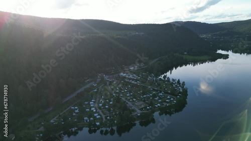 Camping Haven: Caravans, Campers, and Tents Nestled in the Mountains by a Lake on a Summer Day in France photo