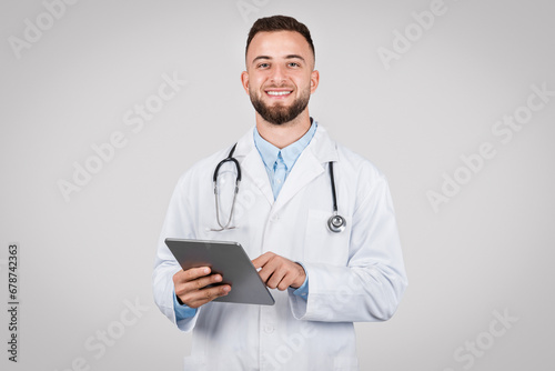 Male doctor holding tablet, friendly and professional