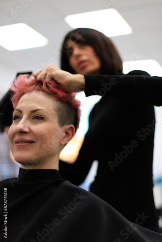Woman at hair salon enjoying new short pink hair look