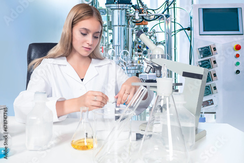 Woman laboratory assistant. Girl at table with bottles. Bioreactor near scientist. Biologist woman works with microscope. Using bioreactor for scientific experiments. Scientist uses bioreactor photo