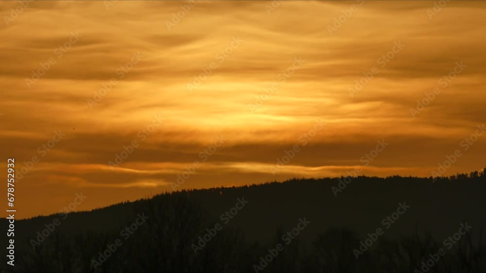 Dark morning orange sky with clouds in shape of waves, flock of birds in flight, sunrise and dark horizon of forests in mountains - timelapse. Dark morning orange sky with clouds in shape of waves, flock of birds in flight, sunrise and dark horizon of forests in mountains - timelapse.