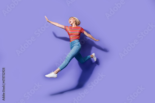 Full body photo of freedom celebrating ukrainian lady jumping air flying hands wings in casual look isolated over violet color background © deagreez