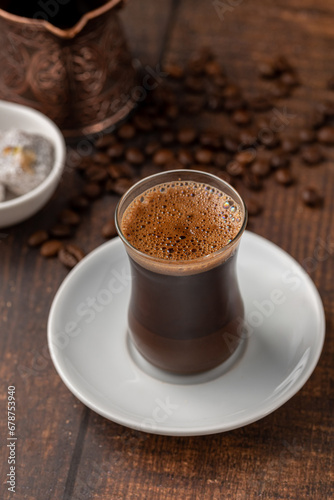 Fototapeta Naklejka Na Ścianę i Meble -  Turkish coffee in glass tea cup with Turkish delight on wooden table