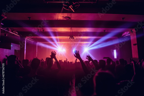 Some people at a music concert lifting their hands in light.