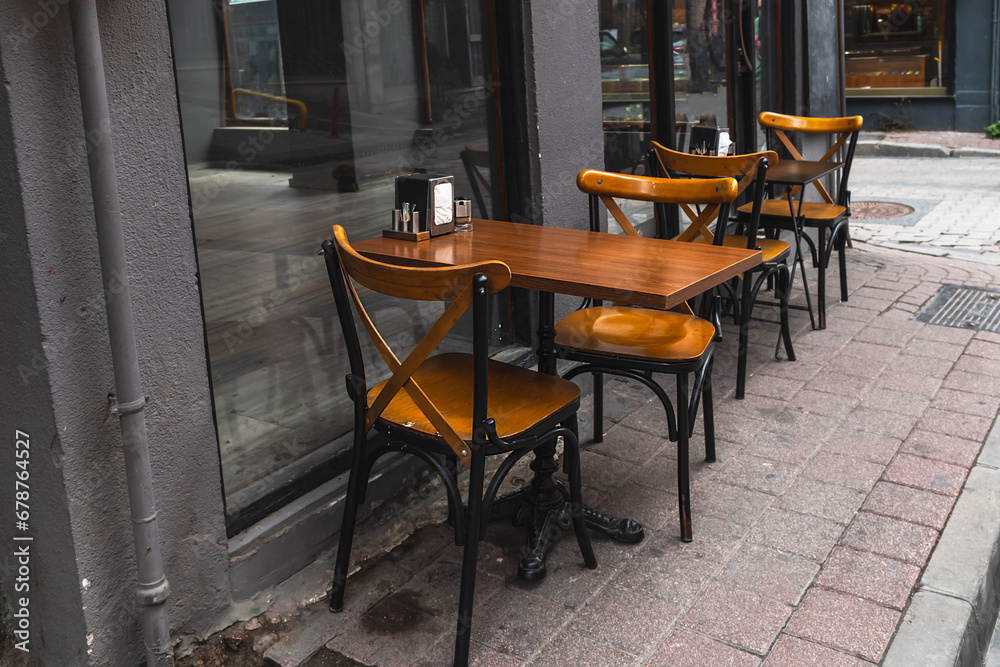 Wooden tables and chairs in a street cafe. Cozy atmosphere of the city. Wooden tables and chairs in a street cafe. Cozy atmosphere of the city.