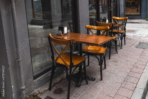 Wooden tables and chairs in a street cafe. Cozy atmosphere of the city.