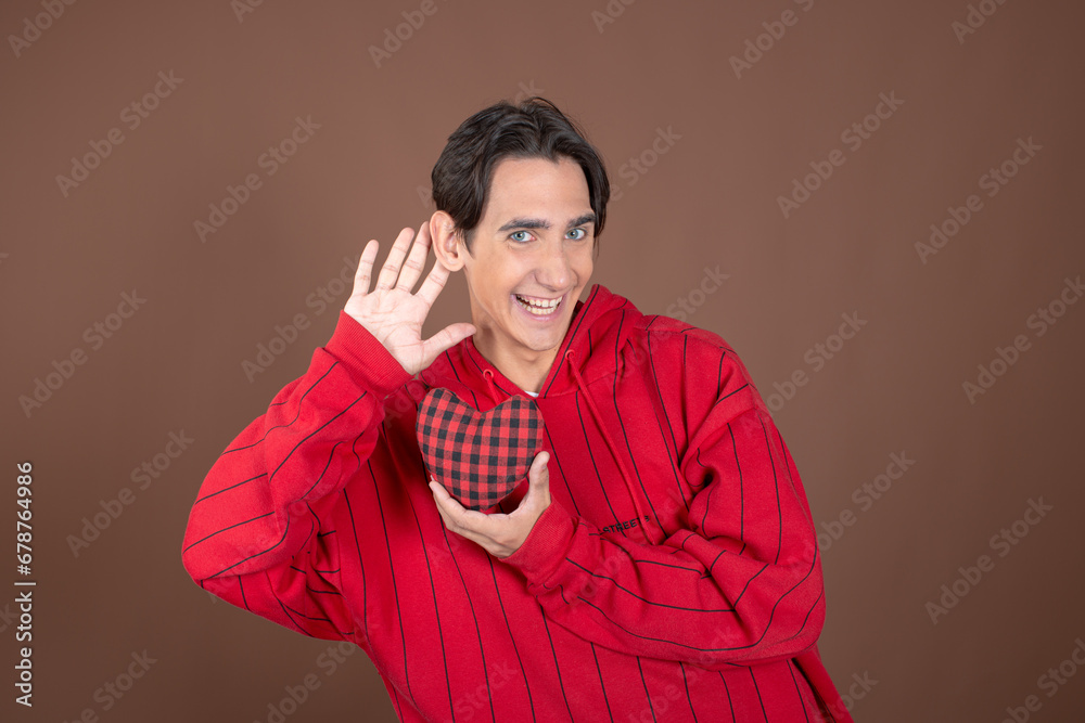 Winter. Christmas is the time of gifts. Funny attractive guy posing on a brown background. Winter. Christmas is the time of gifts. Funny attractive guy posing on a brown background.