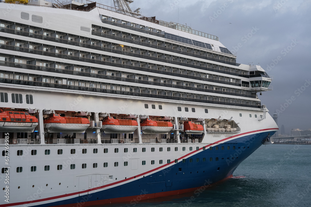 Obraz premium Modern cruiseship or cruise ship liner Freedom arrival into port of Barcelona Espana, Spain gateway in summer during Mediterranean cruising