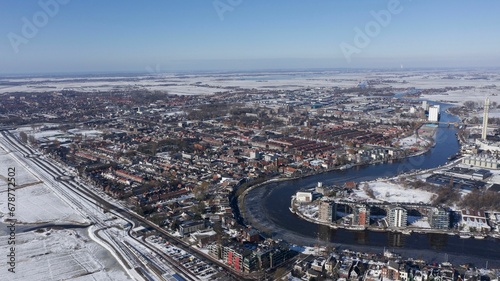 Aerial view of a snowy city with a river © Wirestock