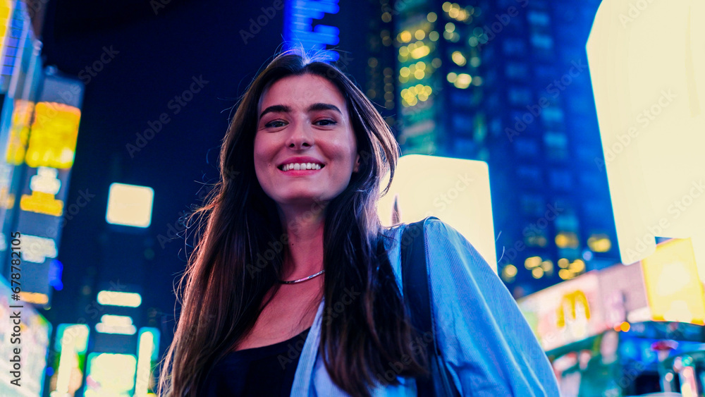 Portrait of joyful cute Caucasian woman looking at camera smiling standing on Times Square in the USA during summer trip. Attractive pretty stylish girl enjoying walk at night. Portrait of joyful cute Caucasian woman looking at camera smiling standing on Times Square in the USA during summer trip. Attractive pretty stylish girl enjoying walk at night.
