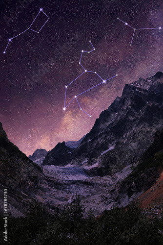 Different constellations in starry sky over mountains at night