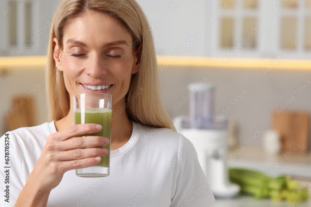 Woman drinking fresh celery juice in kitchen. Space for text Woman drinking fresh celery juice in kitchen. Space for text