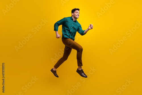 Full length photo of positive nice man wear green trendy clothes look empty space black friday offer isolated on yellow color background