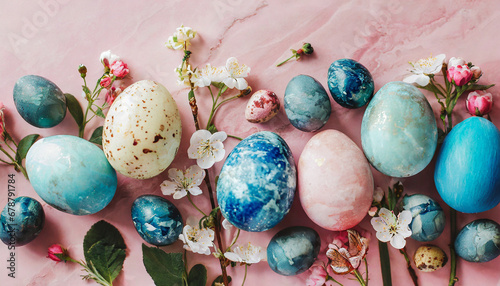 stylish easter eggs and spring flowers border on pink paper flat lay space for text modern natural dyed blue and marble easter eggs happy easter greeting card template photo
