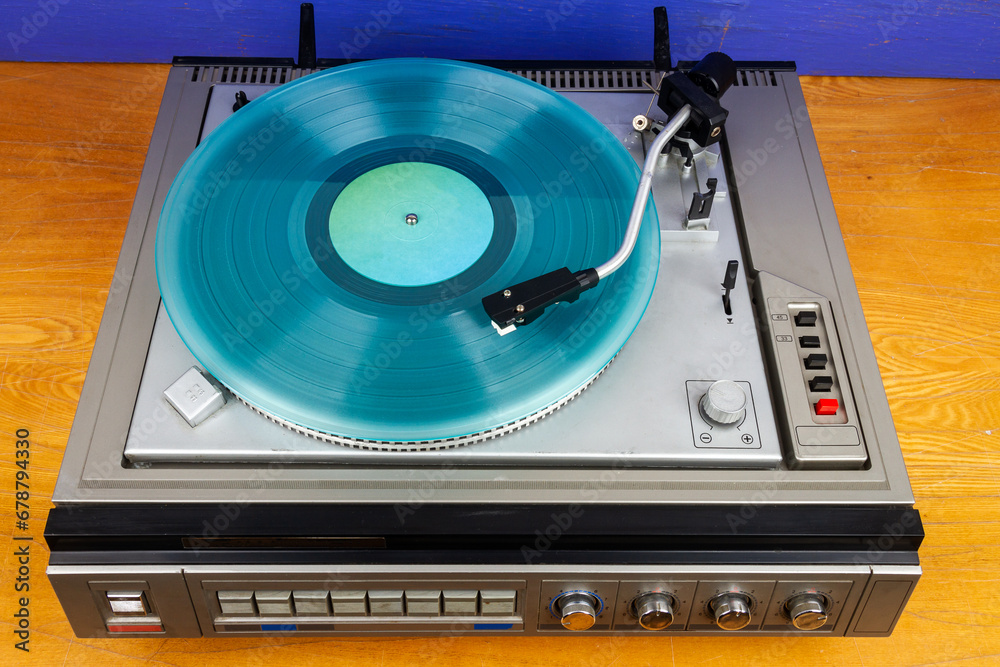 Fototapeta premium Vintage turntable vinyl record player with turquoise vinyl