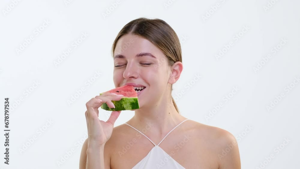Ecstatic Caucasian woman takes a blissful bite into a watermelon, her delight evident in the juicy sweetness of the fruit. Against the clean white backdrop, enthusiasm shines through. Ecstatic Caucasian woman takes a blissful bite into a watermelon, her delight evident in the juicy sweetness of the fruit. Against the clean white backdrop, enthusiasm shines through.