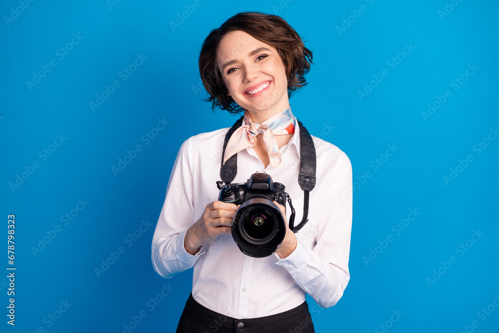 Photo of pretty positive person beaming smile hands hold camera isolated on blue color background Photo of pretty positive person beaming smile hands hold camera isolated on blue color background
