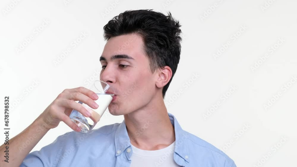 Against a white backdrop, a cheerful Caucasian man grins warmly as he delicately sips water from a crystal clear glass. His eyes sparkle with contentment, and relaxed posture radiates tranquility. Against a white backdrop, a cheerful Caucasian man grins warmly as he delicately sips water from a crystal clear glass. His eyes sparkle with contentment, and relaxed posture radiates tranquility.