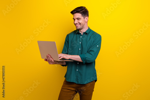 Photo of cheerful man cyber expert wear trendy clothes reading letter chatting with friends macbook isolated on yellow color background