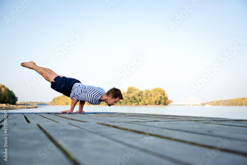 Mid aged man practicing yoga outdoor by the river © sepy