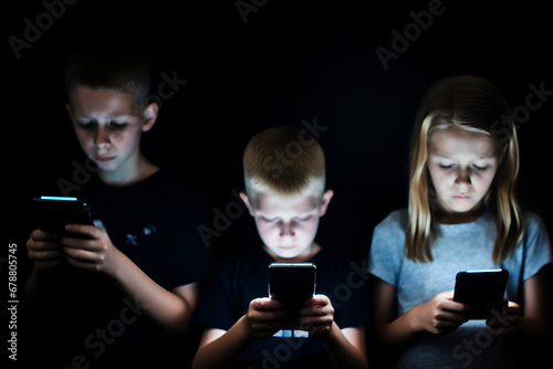 Unhappy young kids hypnotized with mobile phones and smartphones. Children in technology isolation and emotional depression. Internet and social media photo