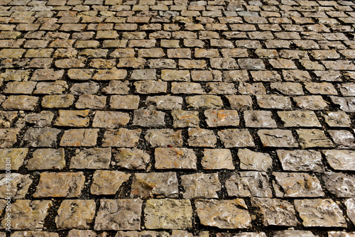 Photos large gray rough surface cobblestone pavement in diminishing perspective