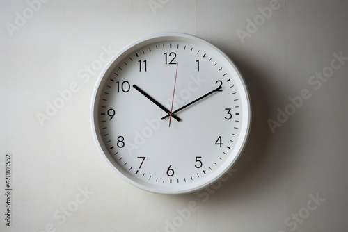Analog wall clock with black minute and hour hands on white