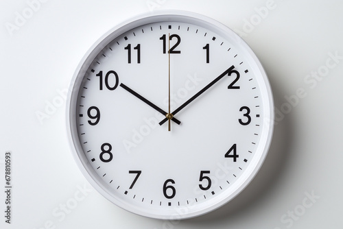 Simple white wall clock with black hands showing ten ten