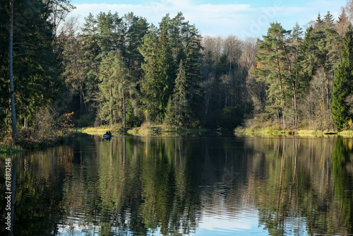 Ņega river in Latvia in autumn. Forest on river shores. Reflection in calm smooth water surface.