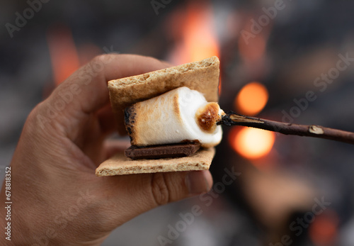 Photography Closeup of S'mores marshmallow, chocolate and crackers by a campfire
