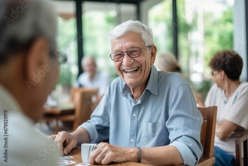 Happy senior man playing card games with friends, activity social networking in nurs home. Concept enjoying playtime together in poker game, old men