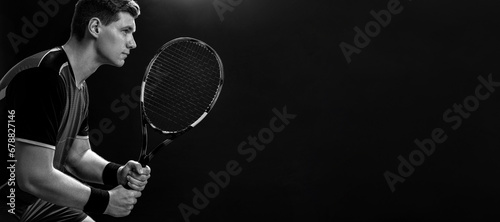 Tennis player with racket closeup. Man athlete playing isolated on black background. Black and white photo © Mike Orlov