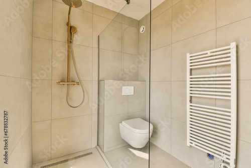 a bathroom with a toilet  shower and towel rack on the wall next to it is a glass enclosed shower door