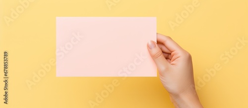 office a person is holding a note a paper memo with adhesive isolated against a plain background containing important information to be posted for communication and human memory