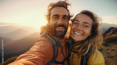 Two happy hikers taking selfie photograph on the top of the hill or mountain with beautiful landscape and sky in the background. © KikkyCNX