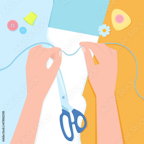 Two female hands with thread on a background of sewing tools