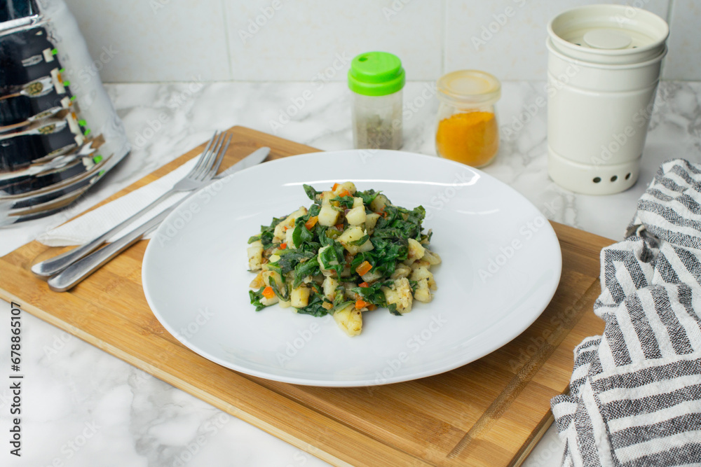Spinach and potatoes recipe served in a white dish Spinach and potatoes recipe served in a white dish