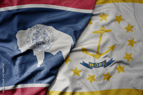 big waving colorful national flag of rhode island state and flag of wyoming state . photo