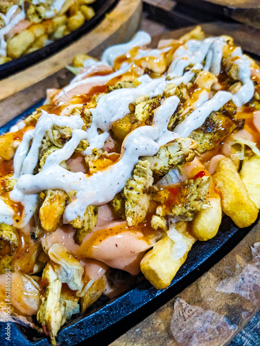 loaded fries topped with a combination of Mayonnaise, sauces and chicken. Full plate of chicken french fries seems very testy