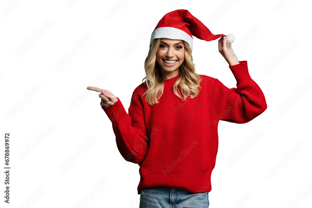 Smiling pretty young blonde woman wearing red sweater and red Santa hat, showing copy space standing isolated on transparent Smiling pretty young blonde woman wearing red sweater and red Santa hat, showing copy space standing isolated on transparent