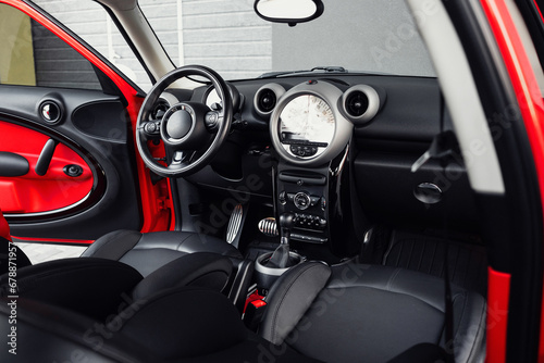 Compact, stylish and youthful crossover in bright red color. Modern black car interior. Details interior. 