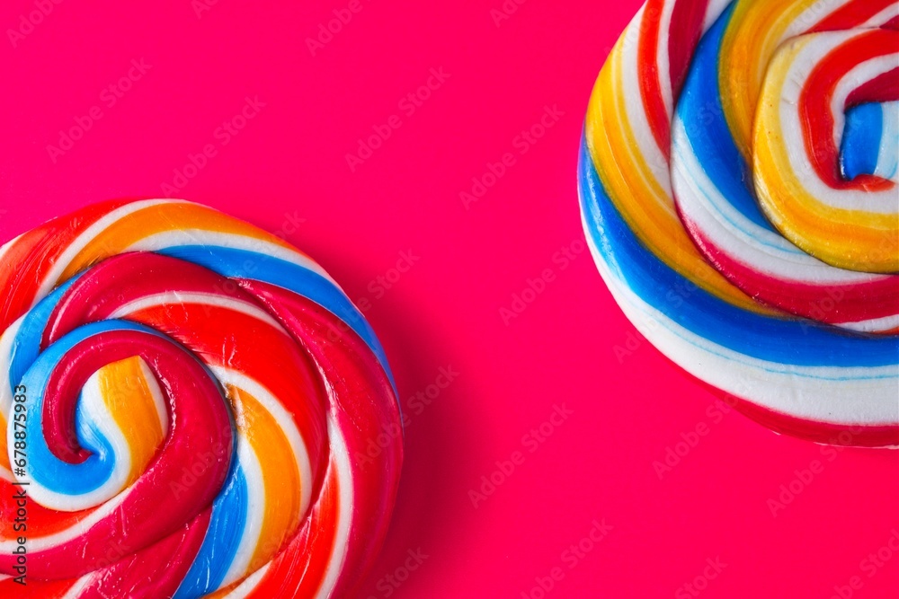 Big bright and colourful candy lollipops on a red background with space for text
