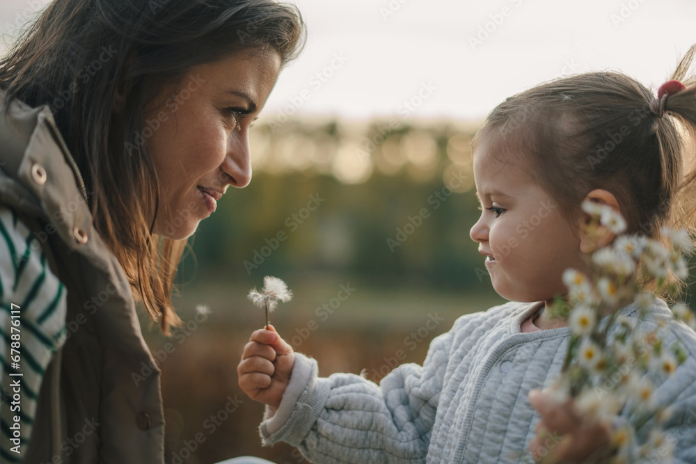 Little baby daughter giving her mother a bouquet of wild flowers. Expressing love and affection to mommy. Little baby daughter giving her mother a bouquet of wild flowers. Expressing love and affection to mommy.