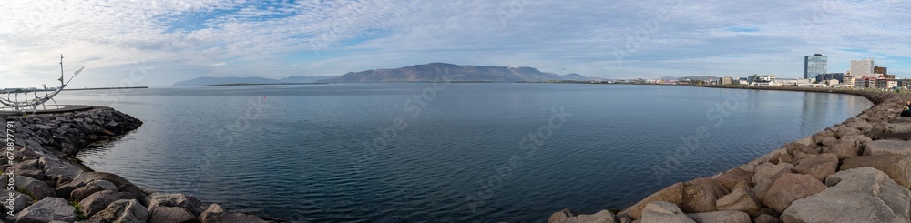 Panoramic view of stunning Reykjavik harbor , ocean and rocky shoreline taken with a fish eye lens