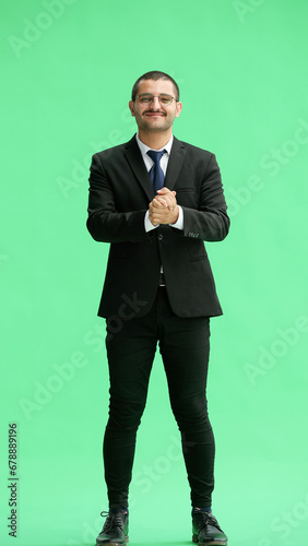 full-length portrait of a young man. standing isolated on green background