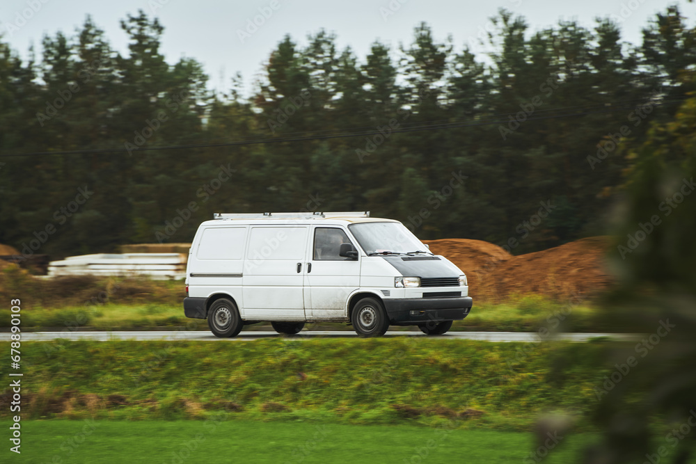 White van. Delivering to Suburban Homes. Commercial Van on the Road Cargo Delivery in the Countryside. Light-Duty Truck in Action.