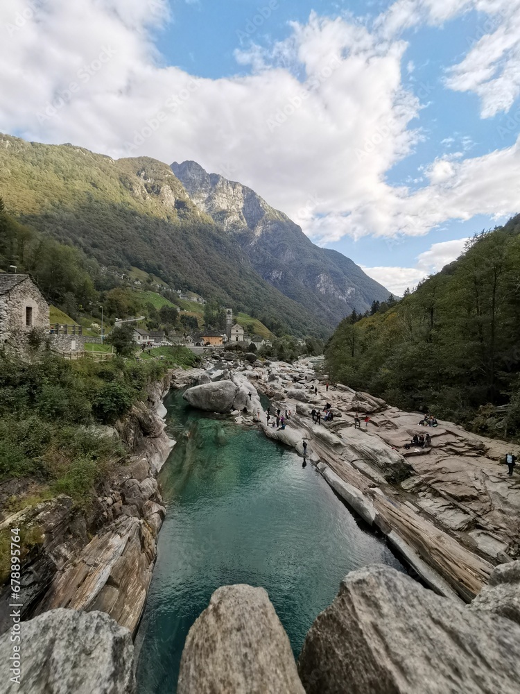 Vertical shot of a river with an imposing mountainscape at Valle Verzasca