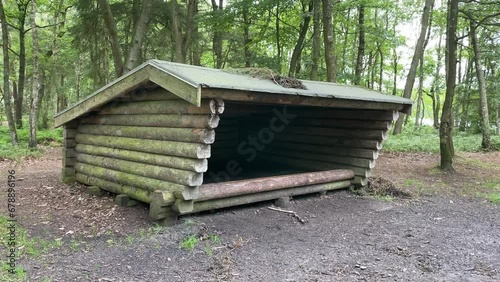 Wooden Shelter in Gudena forest with trees in Denmark, adventure concept photo