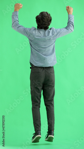 man in full growth. isolated on green background jumping rejoices